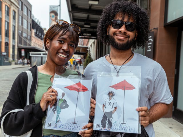 Couple posing with their hand sketched portraits in the Meatpacking District